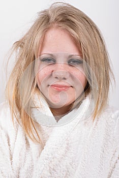 Tired young cute woman in bathrobe