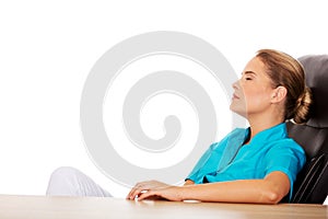 Tired young female doctoror nurse sitting behind the desk