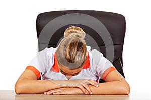 Tired young female doctoror nurse sleeping on the desk