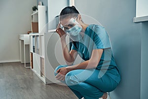 Tired young female nurse in protective workwear