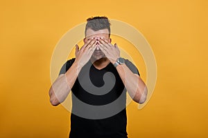Tired young man covered face with palms, unhappy