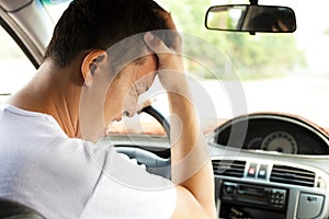 Tired young man have a headache while driving car
