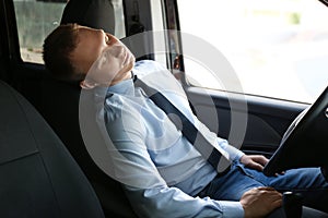 Tired young man sleeping in his modern car