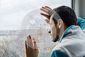 Tired young man suffering from acute pain, male drug addict at rehab clinic