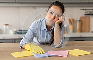 Tired young woman cleaning, showing fatigue after household chores