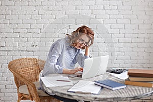 Tired young woman at the computer. A lot of work