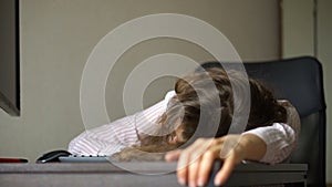 Tired young woman with curly hair and white shirt is working at the office using her laptop, routine work, freelance