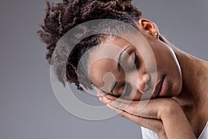Tired young woman dozing with head on hands