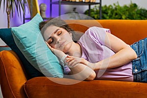 Tired young woman girl lying down in bed taking a rest at home, napping, falling asleep on couch