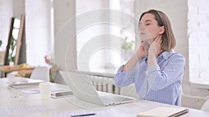 Tired Young Woman having Neck Pain in Modern Office