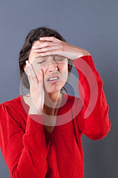 Tired young woman suffering, holding her head for migraine