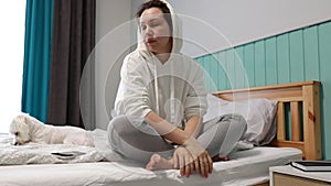 Tired Young Woman Waking Up and Stretching in a Cozy Bedroom at Morning