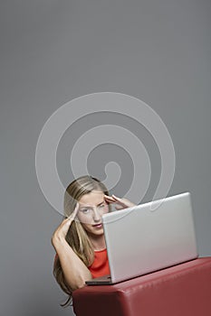 Tired young woman while working on a laptop