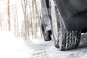 Tires on a snow-covered road, black vehicle, room for copy