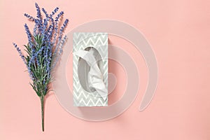 Tissue box and blue lavender on pink background