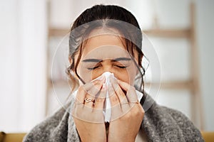 Tissue, nose and sick woman sneezing in living room with allergy, cold or flu in her home. Hay fever, sinusitis and