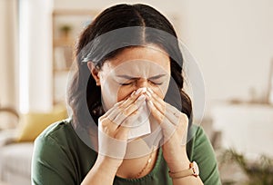 Tissue, nose and sick woman sneezing on a sofa with allergy, cold or flu in her home. Hay fever, allergy and female with