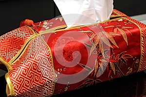 A tissue paper box wrapped in vivid bright red cushion symbolizing prosperity