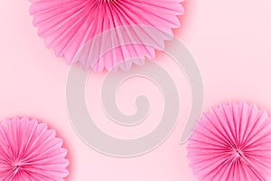 Tissue paper fans scattered on a pink background.