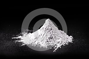 Titanium dioxide TiO2 powder for cosmetics, isolated black background photo