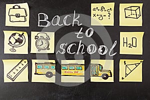Title Back to school written by chalk and images of school bus and attributes written on the pieces of paper