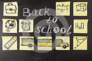 Title Back to school written by chalk and images of school bus and attributes written on the pieces of paper photo