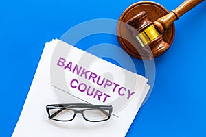 Title of documents the bankruptcy court near judge gavel on blue background top view