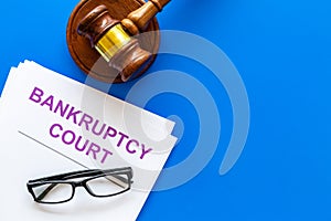 Title of documents the bankruptcy court near judge gavel on blue background top view copy space