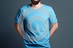 Young man in blank blue t-shirt on grey background. Mock up Ai generative