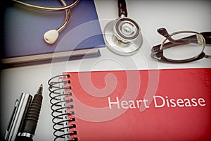 Titled red book Heart Disease along with medical equipment