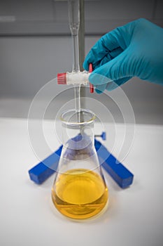 Titration of a solution using an orange indicator. Chemist in a pharmaceutical laboratory