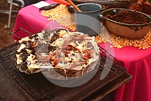 Tlayuda being cooked in the stove or anafre in Mexico, delicious huge tortilla with beans, Oaxaca cheese and jerky beef photo