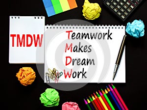 TMDW Teamwork makes dream work symbol. Concept words TMDW Teamwork makes dream work on white note on beautiful black background.