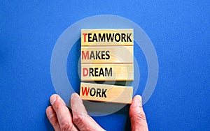 TMDW Teamwork makes dream work symbol. Concept words TMDW Teamwork makes dream work on wooden block on beautiful blue background.