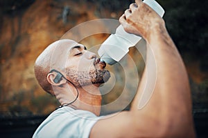 To be successful, you must dedicate yourself 100. a sporty young man drinking water while exercising outdoors.