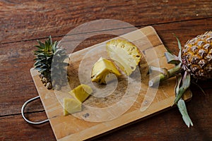 To cut pineapple on a wooden board, cleaning of pineapple, fruit pineapple.