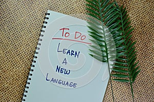 To Do - Learn A New Language write on a book isolated on Wooden Table
