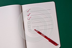To-do list with several points. Open notebook on green background photo