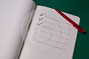 To-do list with several points. Open notebook on green background photo