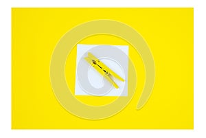 To Do List Sticker with yellow wooden clothespin. Close up of reminder note paper on the yellow background. Copy space. Minimalism