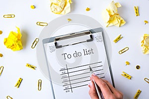 To do list on white background with office supplies. Planning future to stay productive. Flat lay. Top view. Yellow