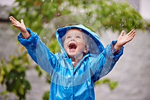 To enjoy the rainbow, first enjoy the rain. Shot of a young girl playing outside in the rain.