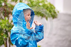To enjoy the rainbow, first enjoy the rain. a young girl playing outside in the rain.