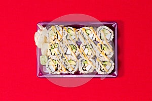 To go sushi box on red table cloth with wasabi ginger