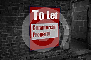 To let with commercial property written on a sign attached to a brick wall