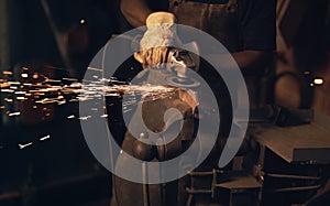 To make art, youve got to make a spark. Shot of a man using an angle grinder while working at a foundry.