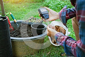 To measure soil pH, gardeners are using a monitor to measure pH balance, acidity, and alkalinity, use of modern agricultural tools