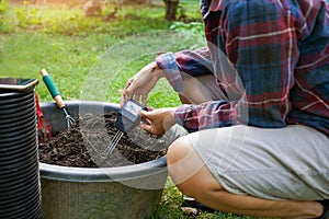 To measure soil pH, gardeners are using a monitor to measure pH balance, acidity, and alkalinity, use of modern agricultural tools