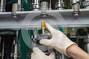 To operate a CNC machine, a worker selects and inspects the required cutter from the rack and tool cabinet