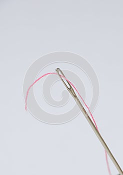 To run a thread through an eyelet